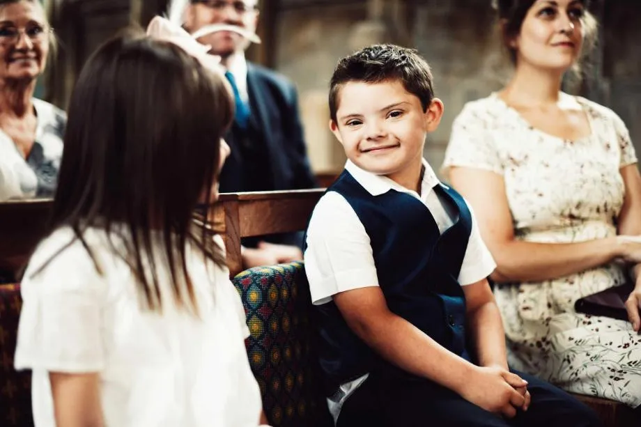 Boy with Down's syndrome sitting on pew in church