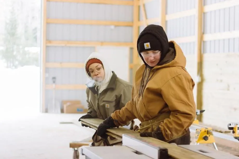 vanguard women cutting down wood board
