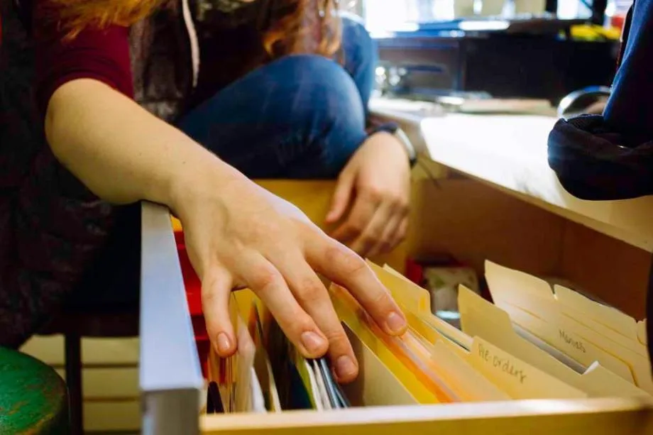 person reaching into file cabinet