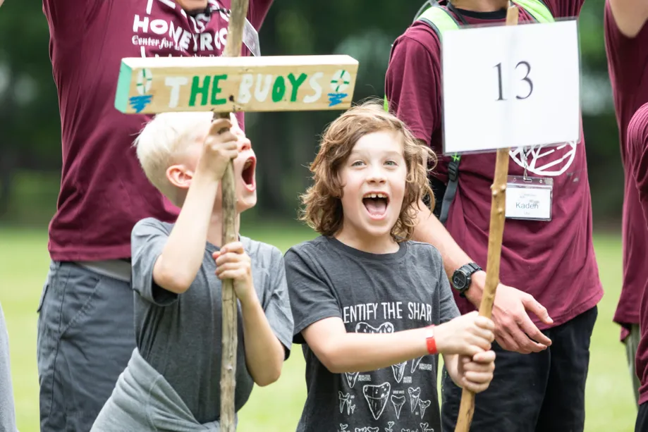 Two kids holding signs