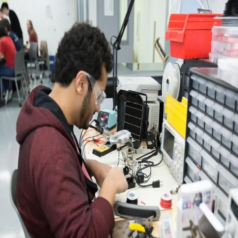 Engineering student works on project with lab glasses