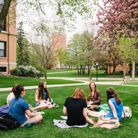 Dr. Tiffany Eberle Kriner and students sitting outside on the lawn