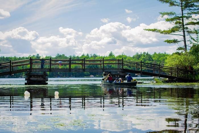 family canoes under bridge at honeyrock