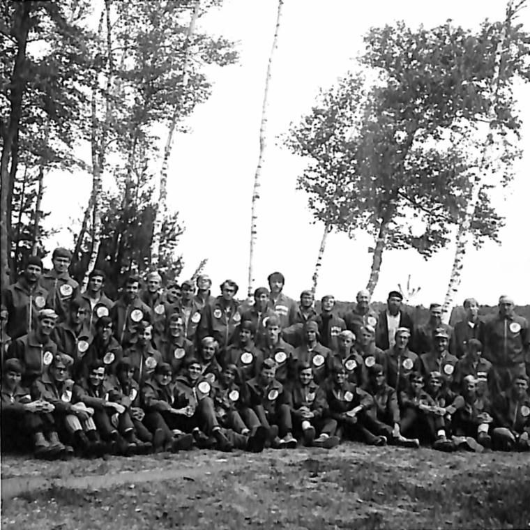 an early group of Vanguards sit by the lake
