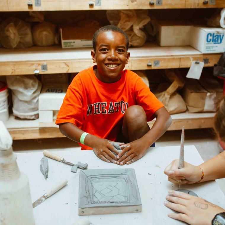 camper boy crafting in the ceramics studio