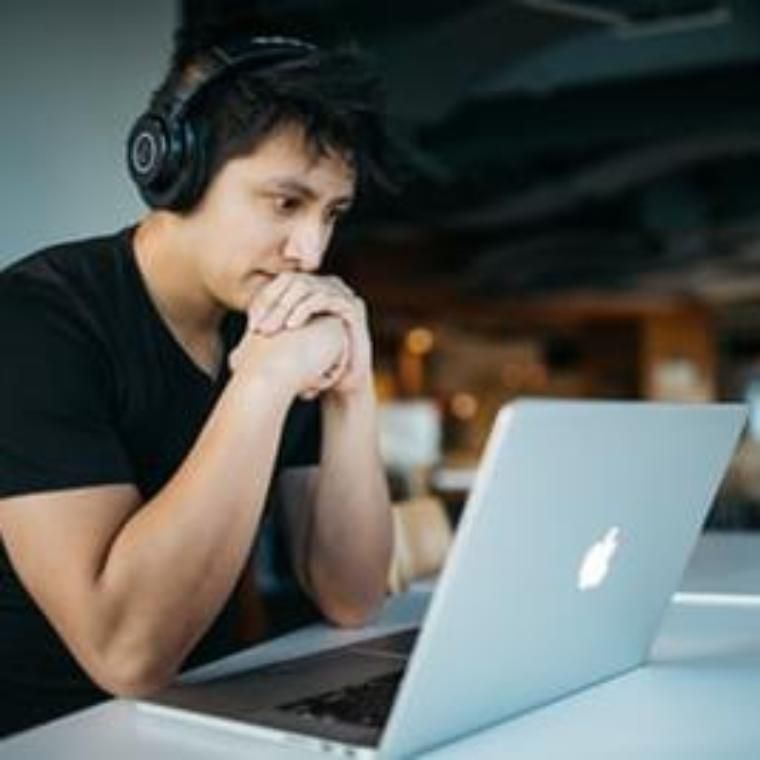 Man working on computer with  headphones