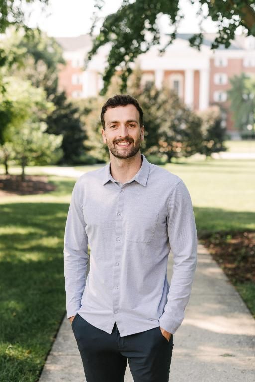 Man in button down shirt standing with Billy Graham Hall in the background