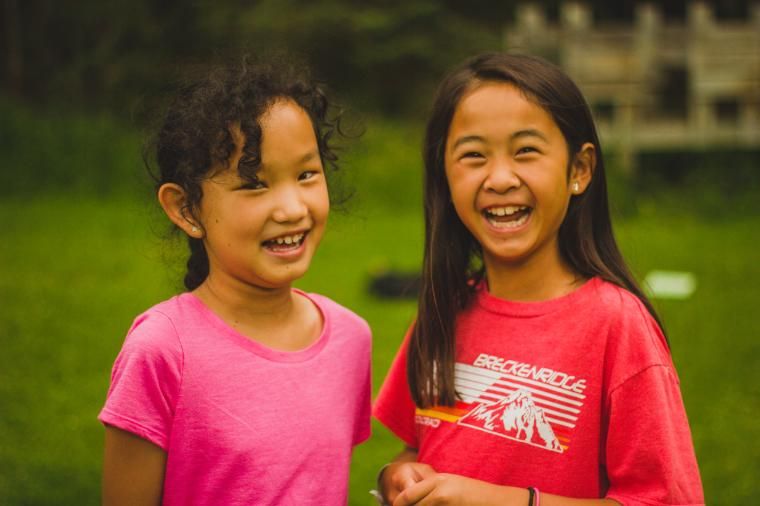 camper girls smiling on chrouser lawn at HoneyRock