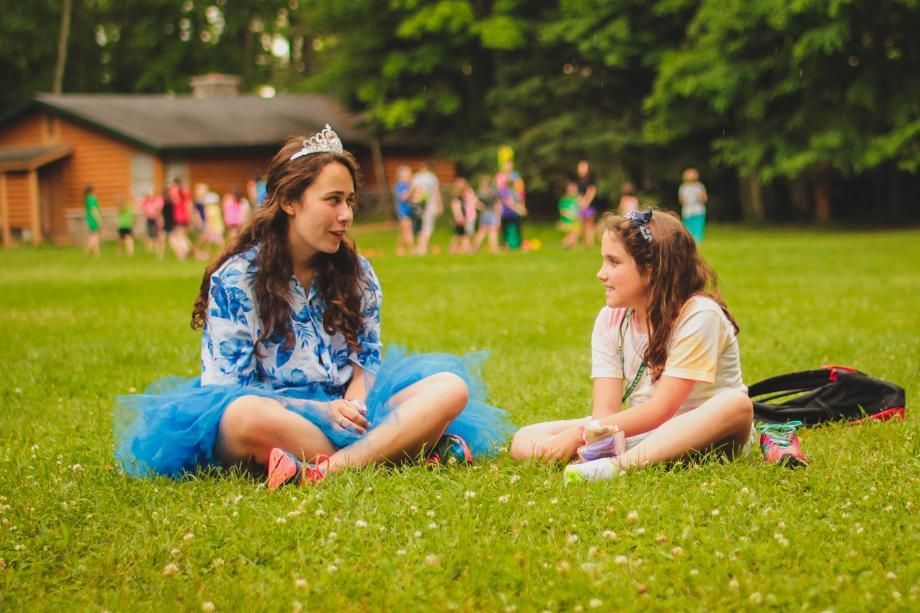 camper and counselor talking on the lawn