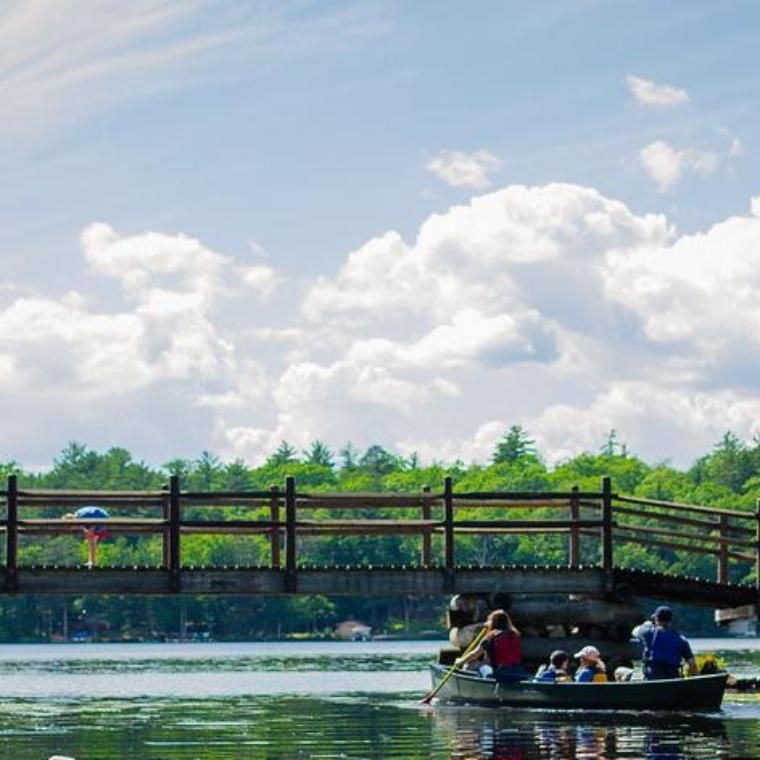 family canoes under bridge at honeyrock