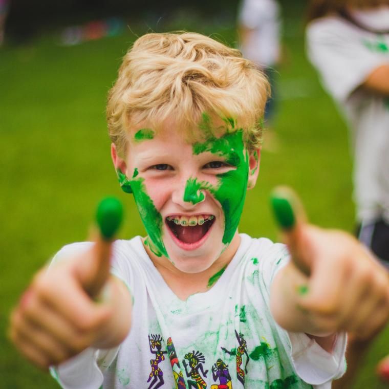 boy gives two thumbs up to camera