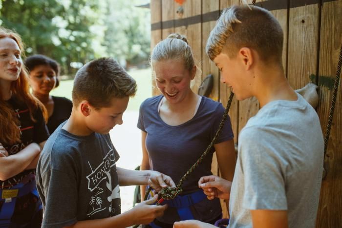 leader teaches camper to tie a knot