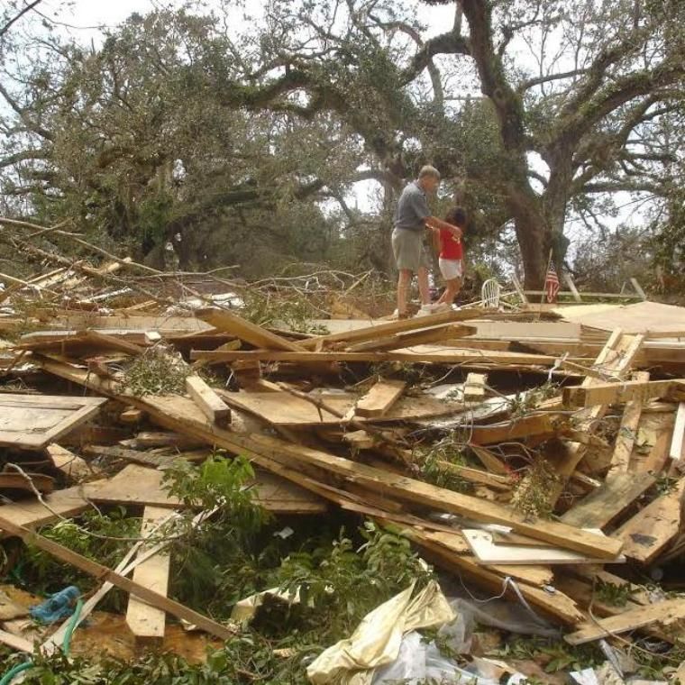 People walking on top of disaster ruins