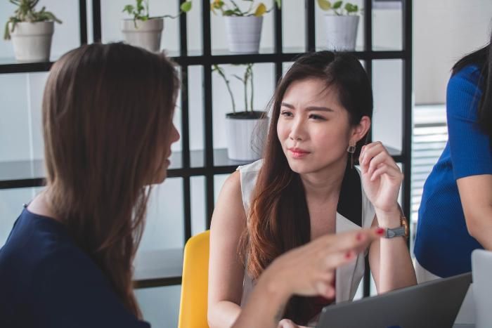 2 women talking with computer