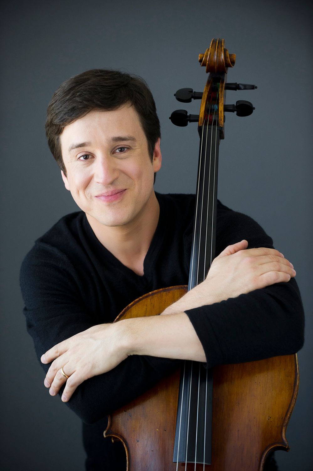 Dr. Altino, professor headshot with arms crossed over cello