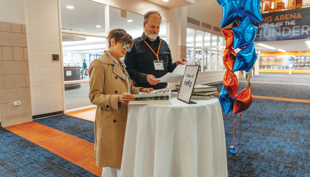 Amy Wasson Throw ’86 and Daniel Throw ’83 look through attendee names at reunion check-in.