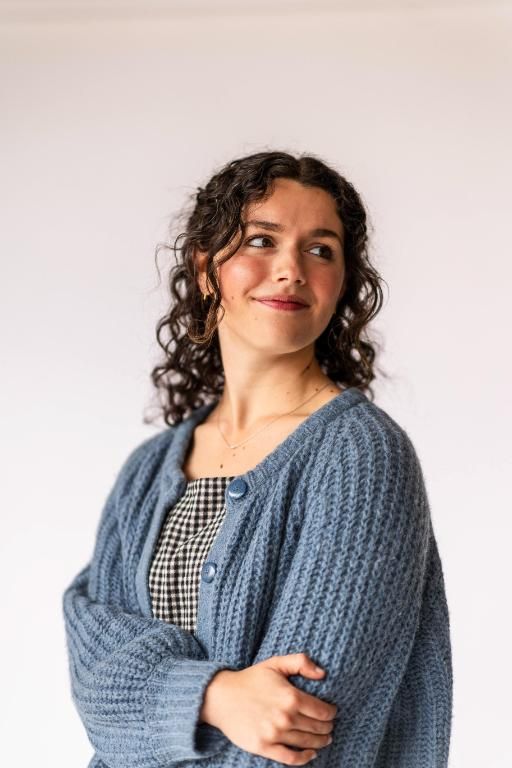 Doctoral student wearing a blue sweater and black and white gingham dress - Wheaton College Graduate School Bible and Theology Program